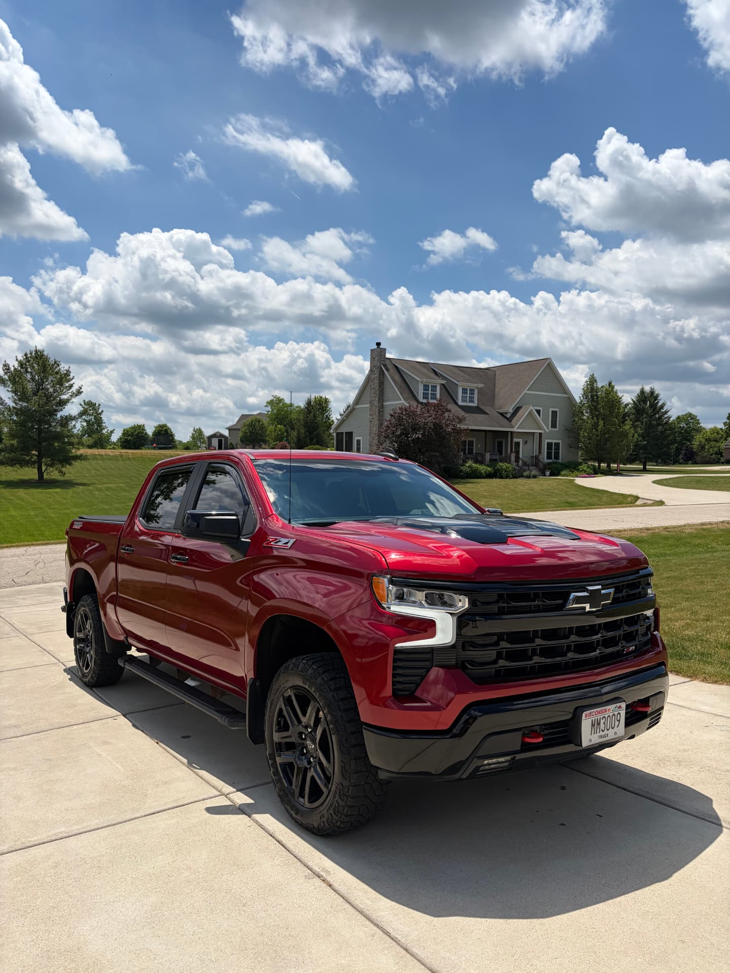 Freshly detailed red Chevrolet Silverado Trail Boss on a Wisconsin driveway