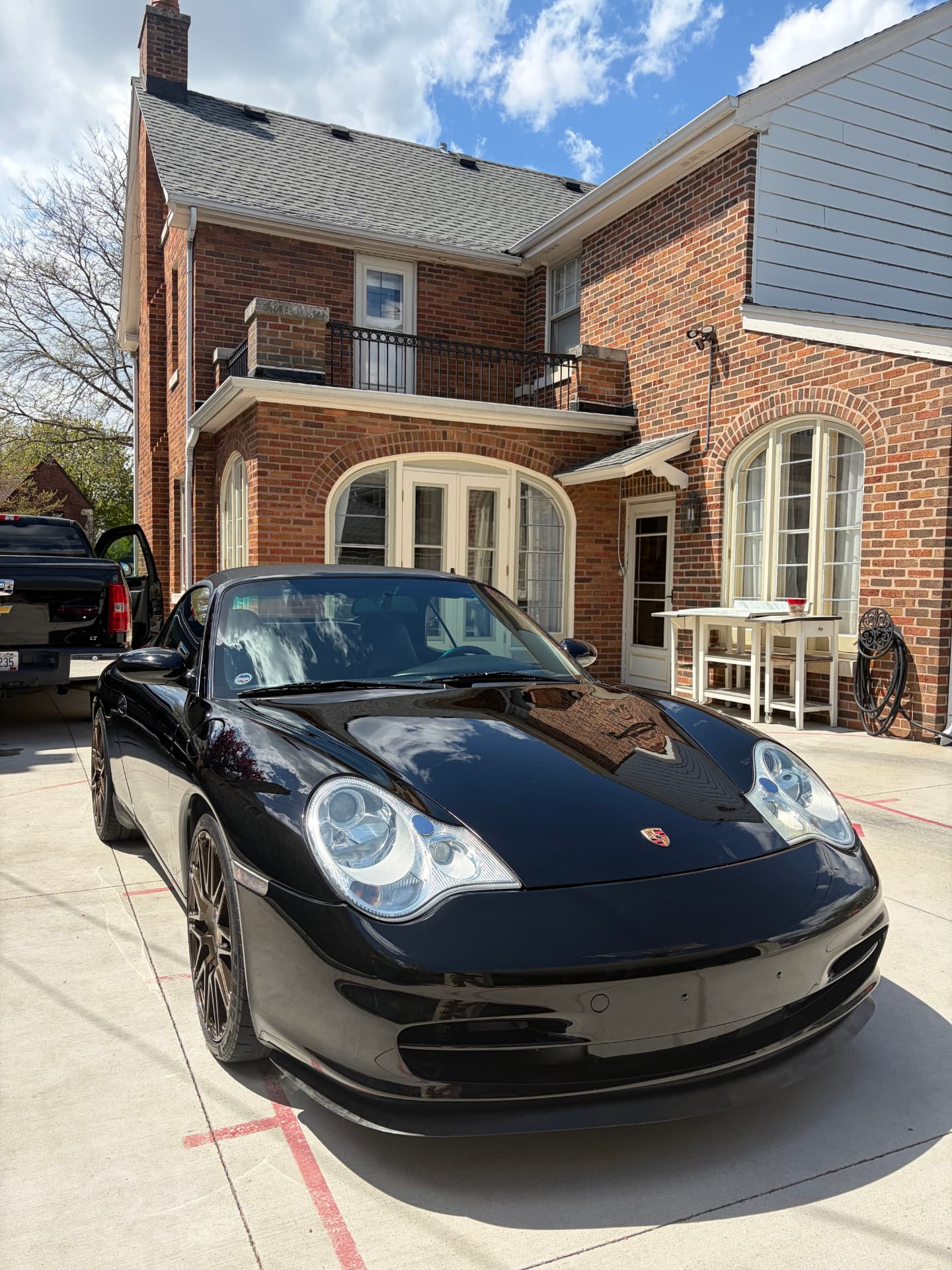 Freshly detailed black Porsche 911 Carrera 4S on a driveway