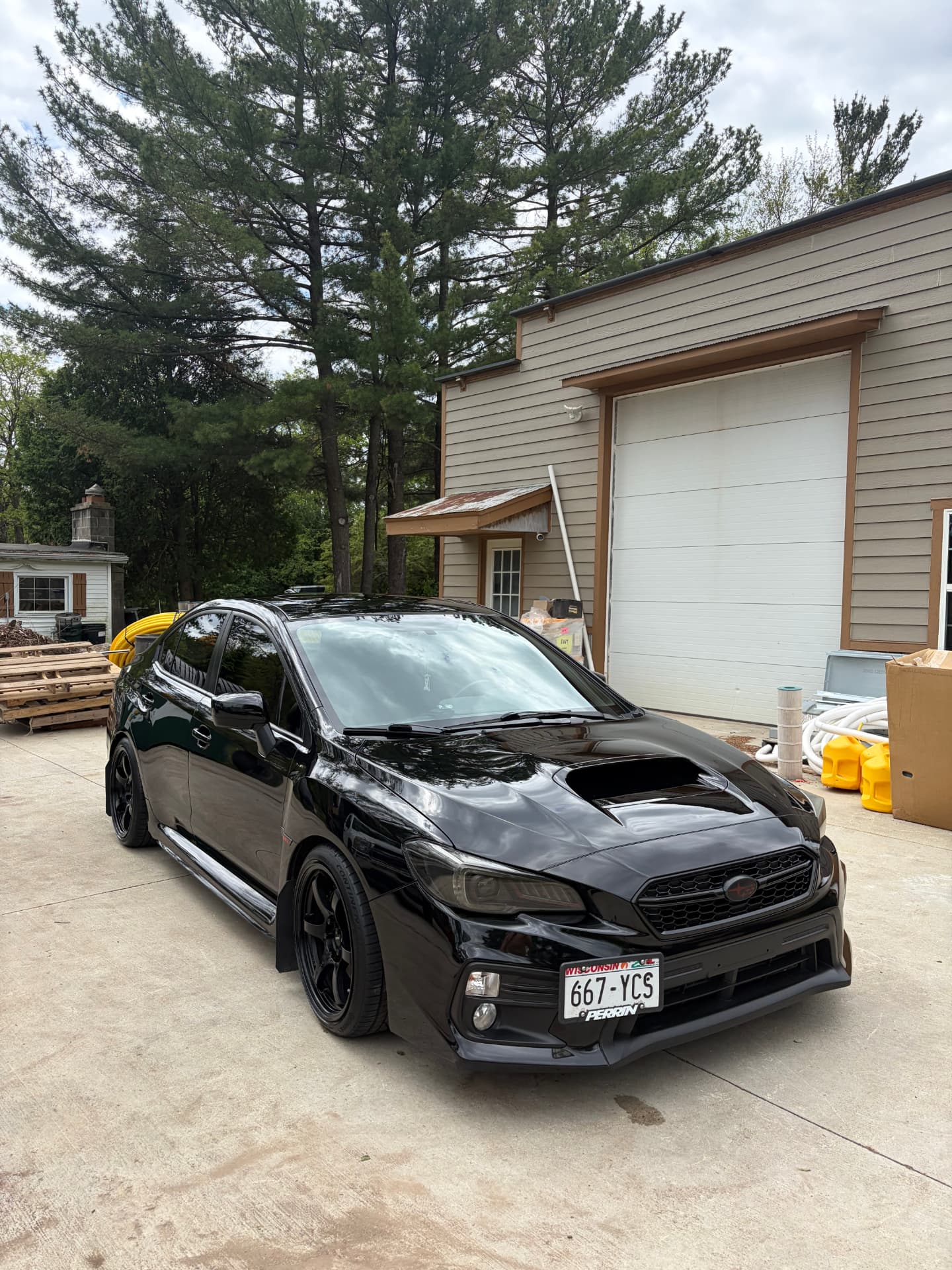 Freshly detailed black Subaru WRX on a Wisconsin driveway