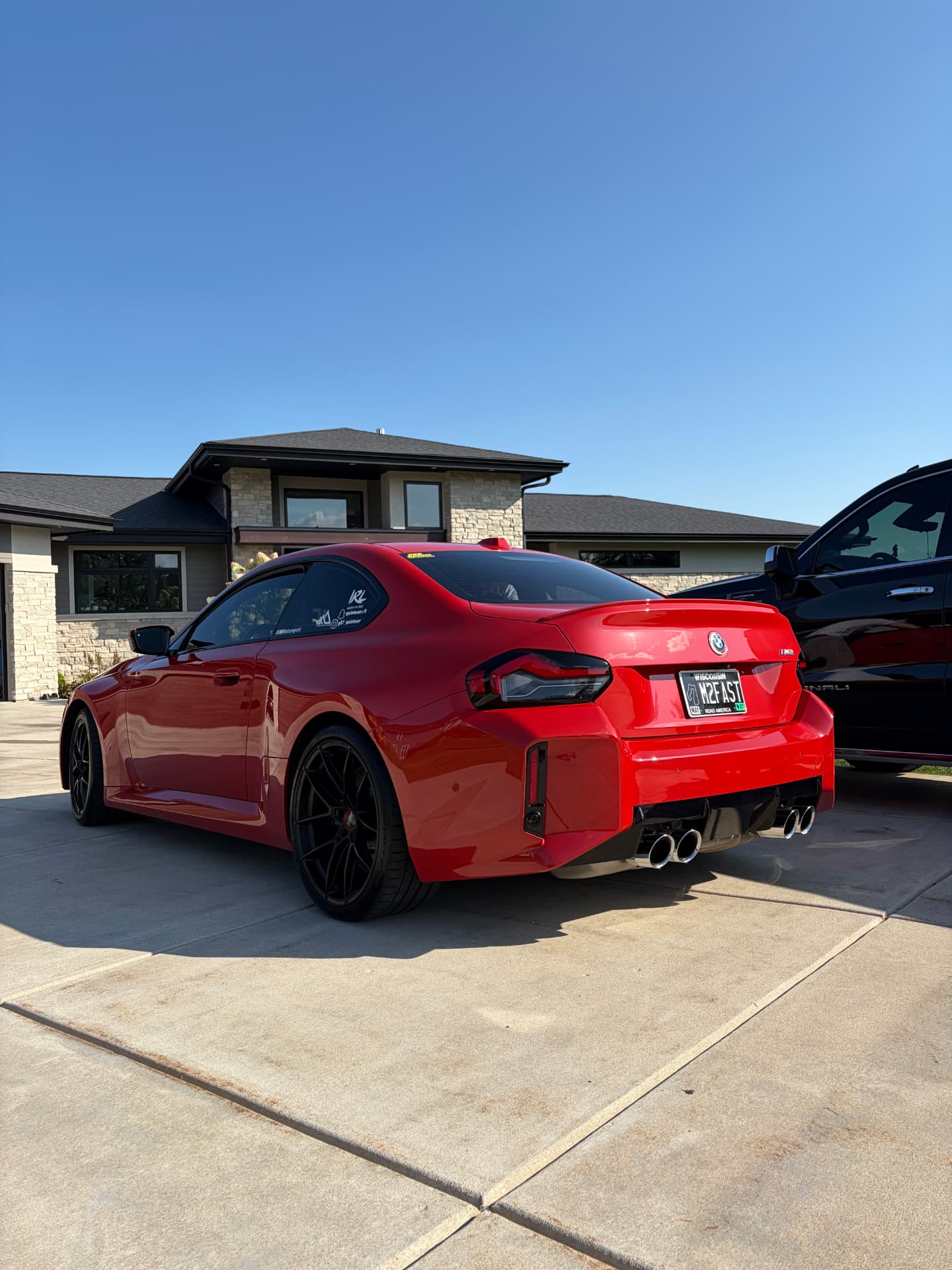 Glossy red BMW M2 after an exterior detail on a Waukesha driveway